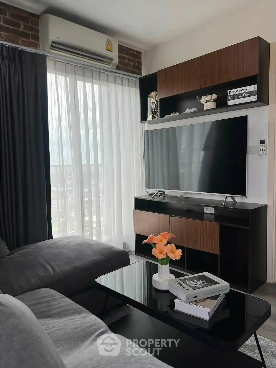 Modern living room with sleek TV unit and cozy sofa, perfect for relaxation and entertainment.