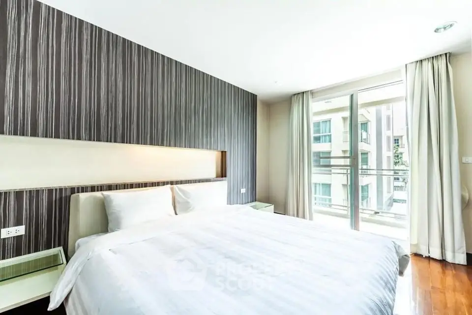 Modern bedroom with large window and stylish decor in a luxury apartment.