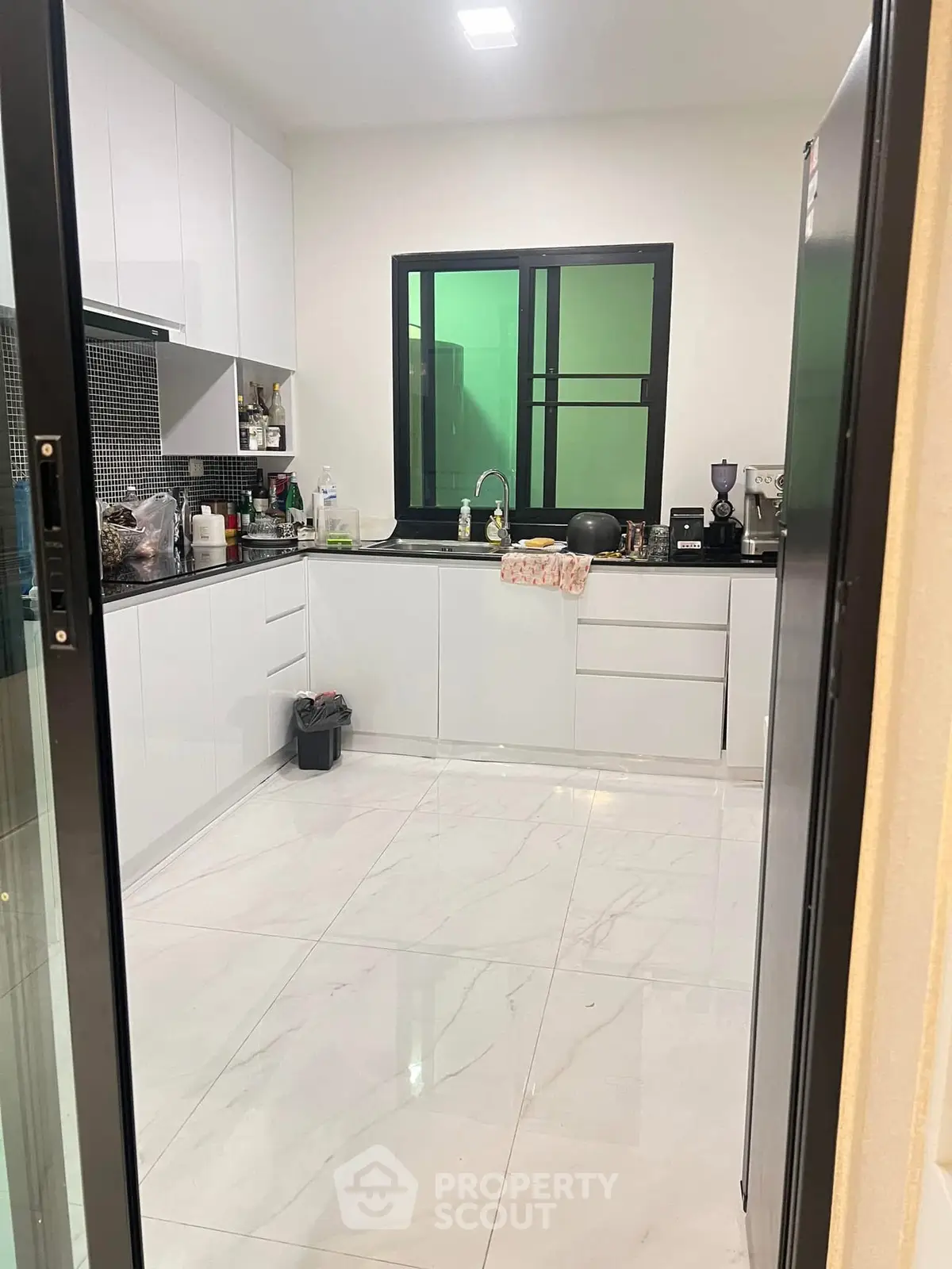 Modern kitchen with sleek white cabinets and glossy tile flooring