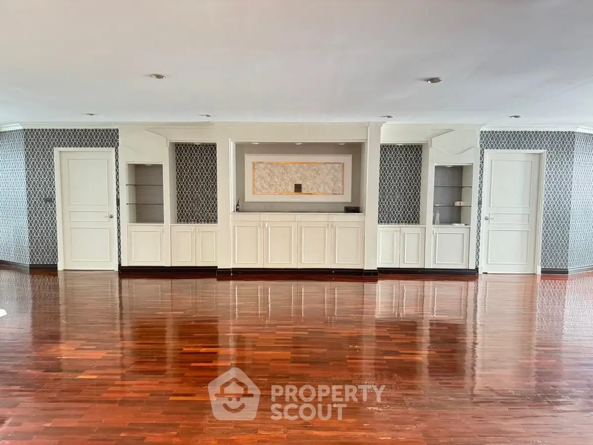 Spacious living room with elegant wooden flooring and built-in cabinetry