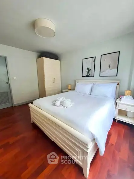 Spacious bedroom with elegant wooden flooring and stylish decor