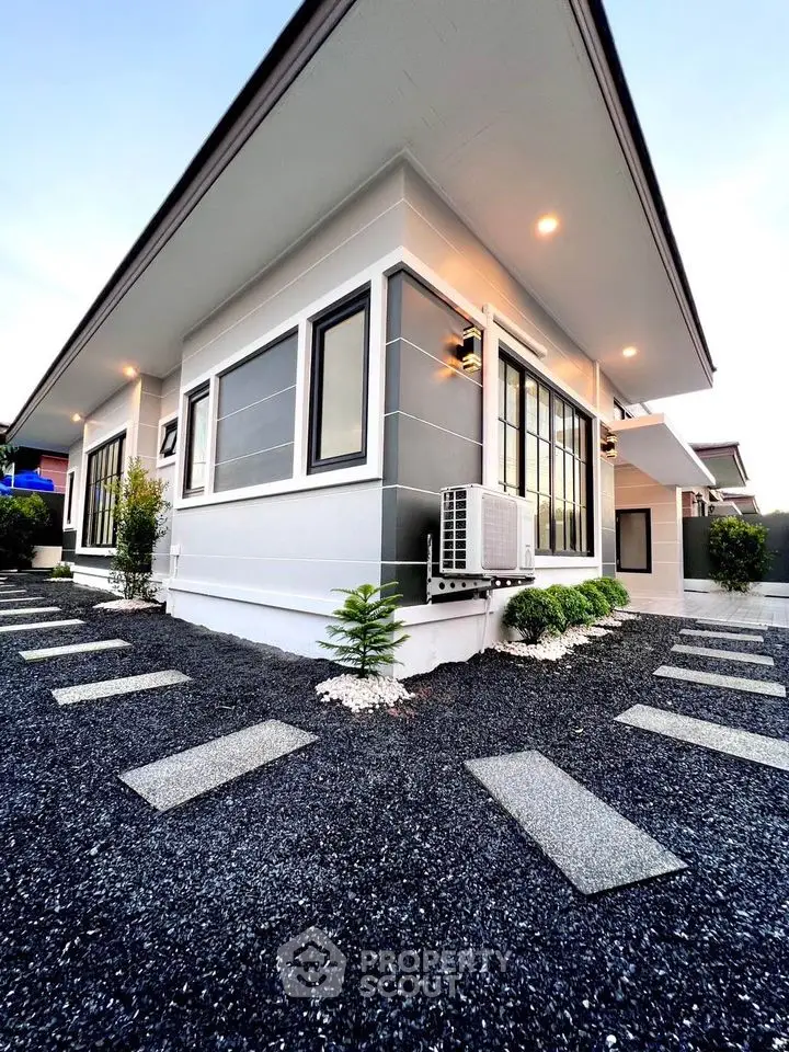 Modern single-story house with sleek design and landscaped garden path