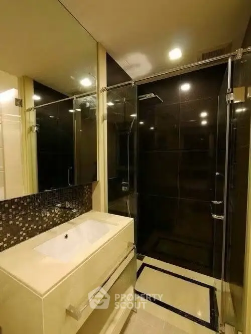 Modern bathroom with sleek glass shower and stylish vanity in luxury apartment.