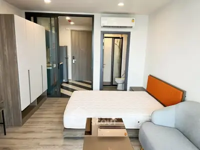 Modern studio apartment with stylish furnishings and sleek design, featuring a cozy bed and contemporary decor.
