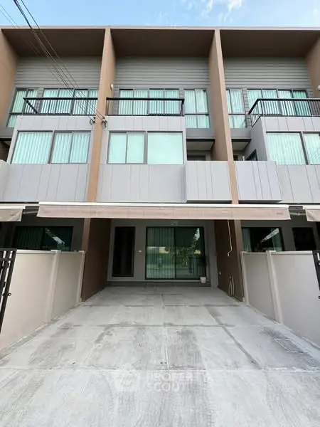 Modern townhouse exterior with spacious driveway and large windows