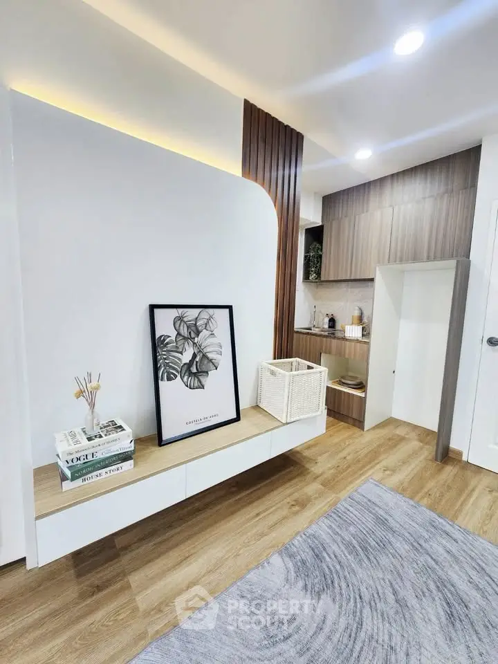 Modern living room with stylish decor and wooden flooring, featuring a cozy seating area and contemporary artwork.