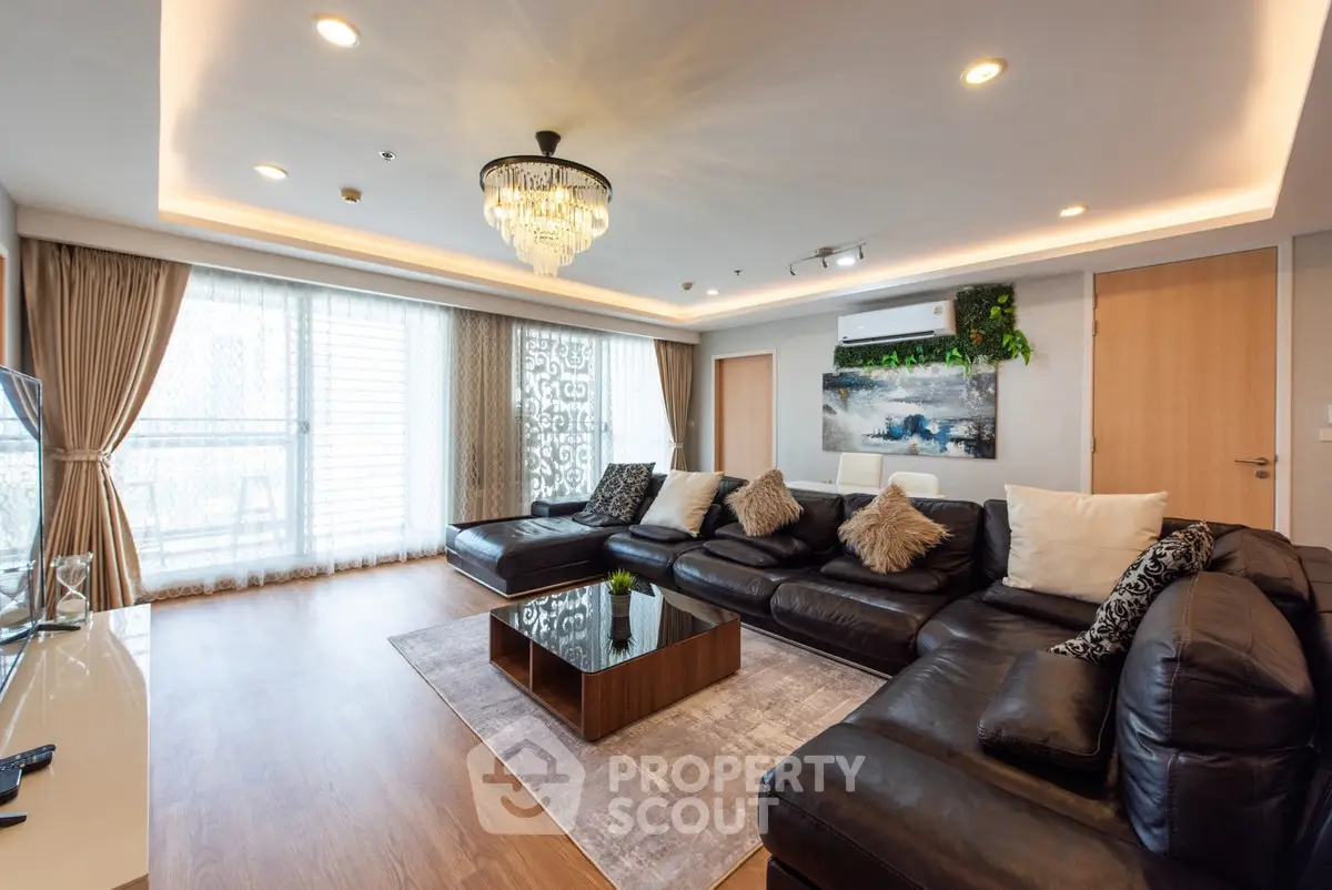 Luxurious living room with elegant chandelier and plush leather sofas