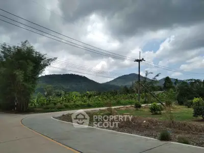 Scenic view of lush green landscape with mountains and cloudy sky, perfect for nature lovers.