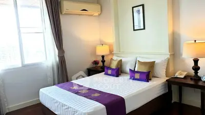 Elegant bedroom with stylish decor and natural light, featuring a cozy bed and ambient lighting.