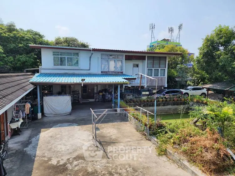 Charming two-story house with spacious driveway and lush greenery, perfect for family living.