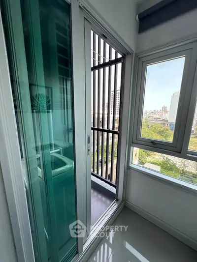 Modern apartment balcony with sliding glass doors and city view