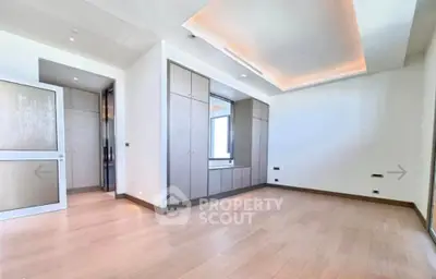 Spacious modern bedroom with elegant wood flooring and built-in wardrobe