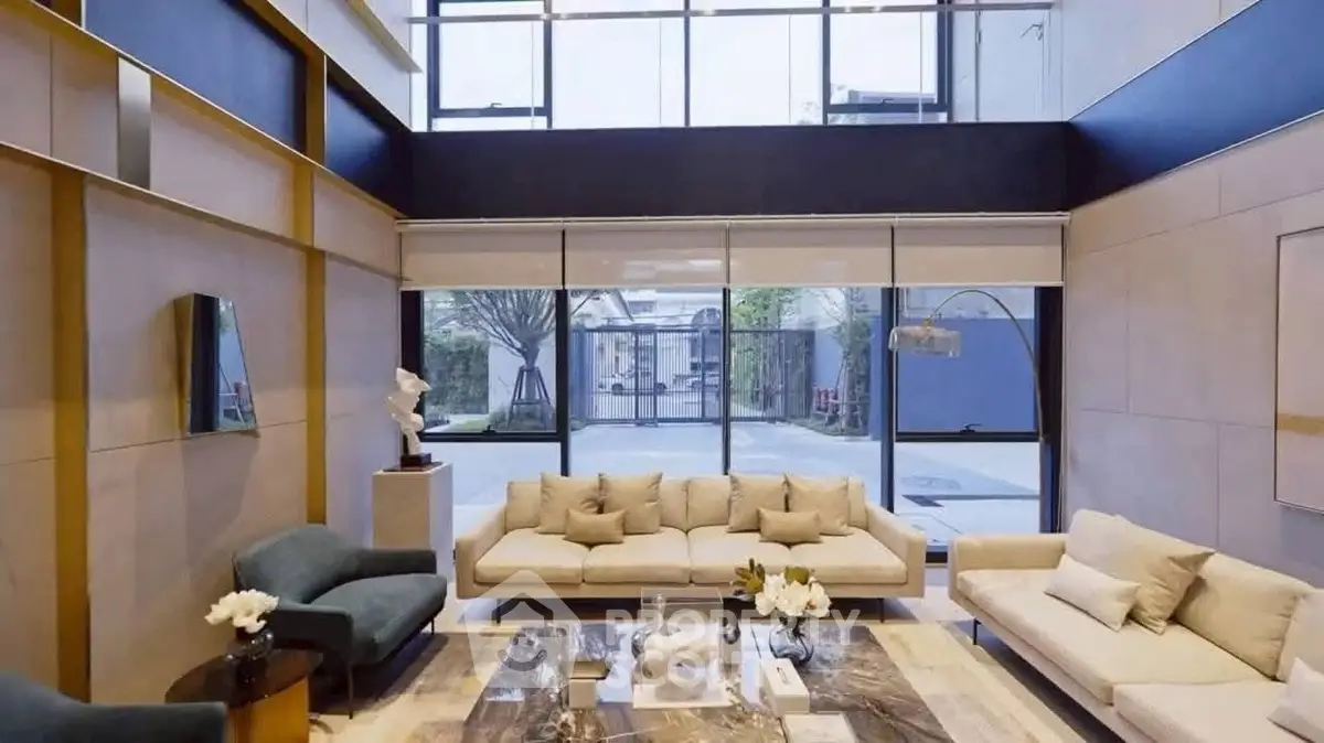 Luxurious modern living room with high ceilings and large windows offering garden views.