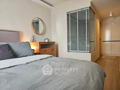 Modern bedroom with stylish decor and natural light, featuring a cozy bed and elegant furnishings.