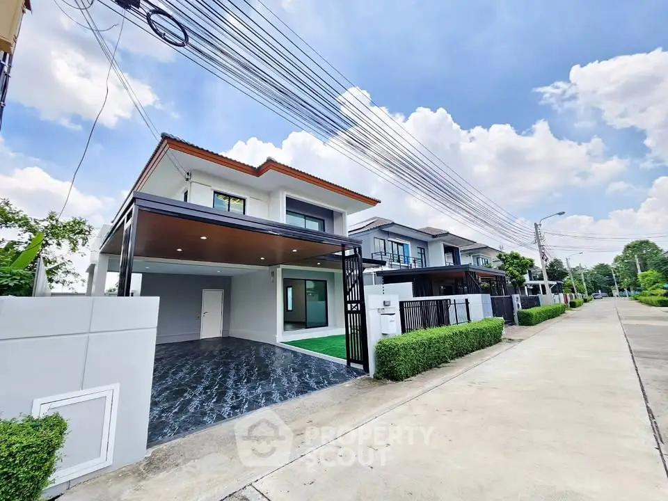 Modern two-story house with driveway and lush greenery in a serene neighborhood.