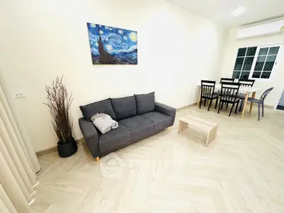 Modern living room with stylish decor and dining area, featuring a comfortable sofa and elegant flooring.