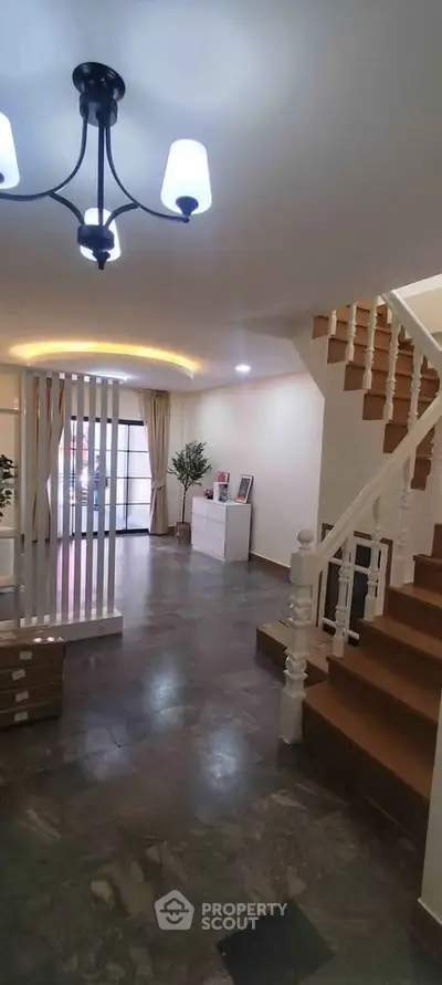 Elegant interior with modern staircase and stylish lighting in a spacious living area.