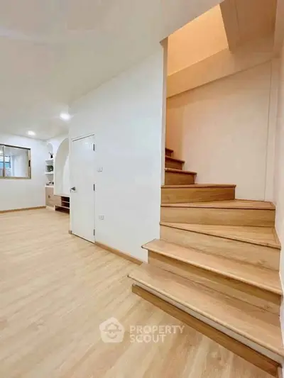Spacious modern interior with wooden staircase and open living area, perfect for family gatherings.