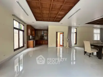 Spacious open-plan living area with elegant wooden ceiling and modern dining space.