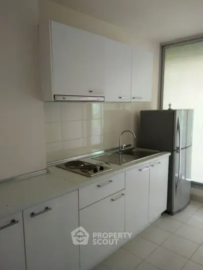Modern kitchen with sleek white cabinetry and stainless steel appliances.