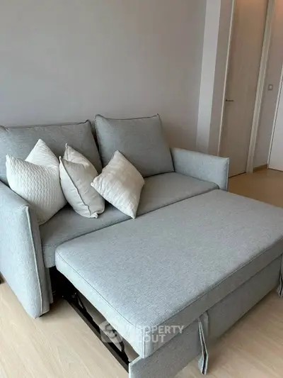 Modern living room with stylish gray sofa bed and decorative pillows