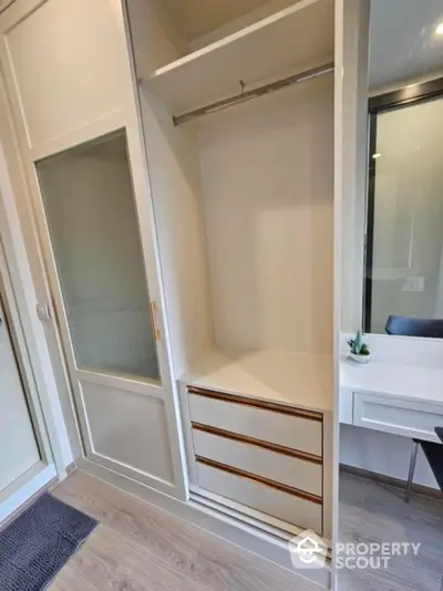 Spacious modern wardrobe with sliding doors and built-in drawers in stylish apartment.