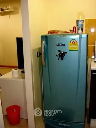 Compact kitchen corner with retro-style blue fridge and modern decor