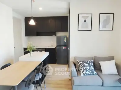 Modern open-plan kitchen and living room with stylish decor and natural light.