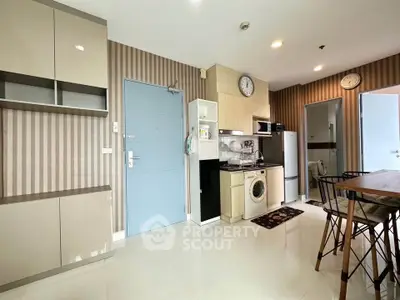 Modern kitchen with stylish cabinetry and dining area in a cozy apartment setting.