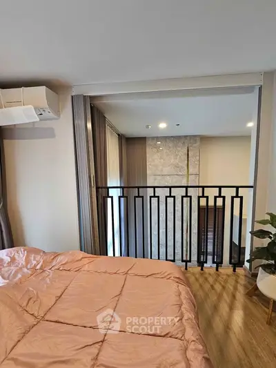 Modern bedroom with stylish railing and cozy bedding in a contemporary apartment.