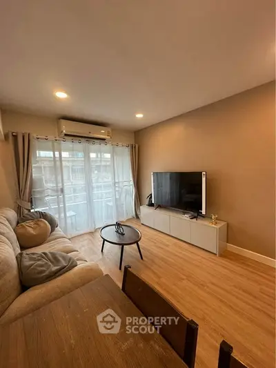 Cozy living room with modern decor and large window for natural light.