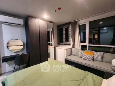 Modern bedroom with stylish decor, large windows, and cozy seating area.