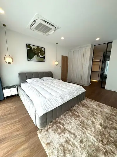 Luxurious modern bedroom with stylish decor and plush bedding in a spacious apartment.