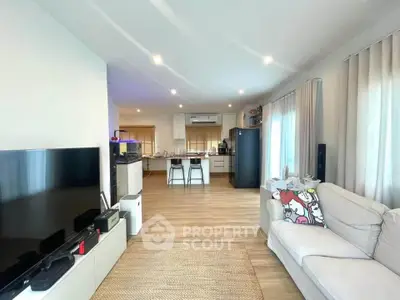 Spacious open-plan living room with modern kitchen and cozy seating area.