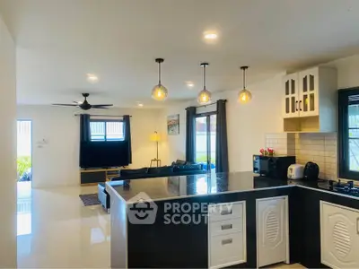 Modern open-layout kitchen and living room with sleek design and ample natural light.