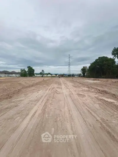 Expansive vacant land with development potential under a cloudy sky, ideal for new construction projects.