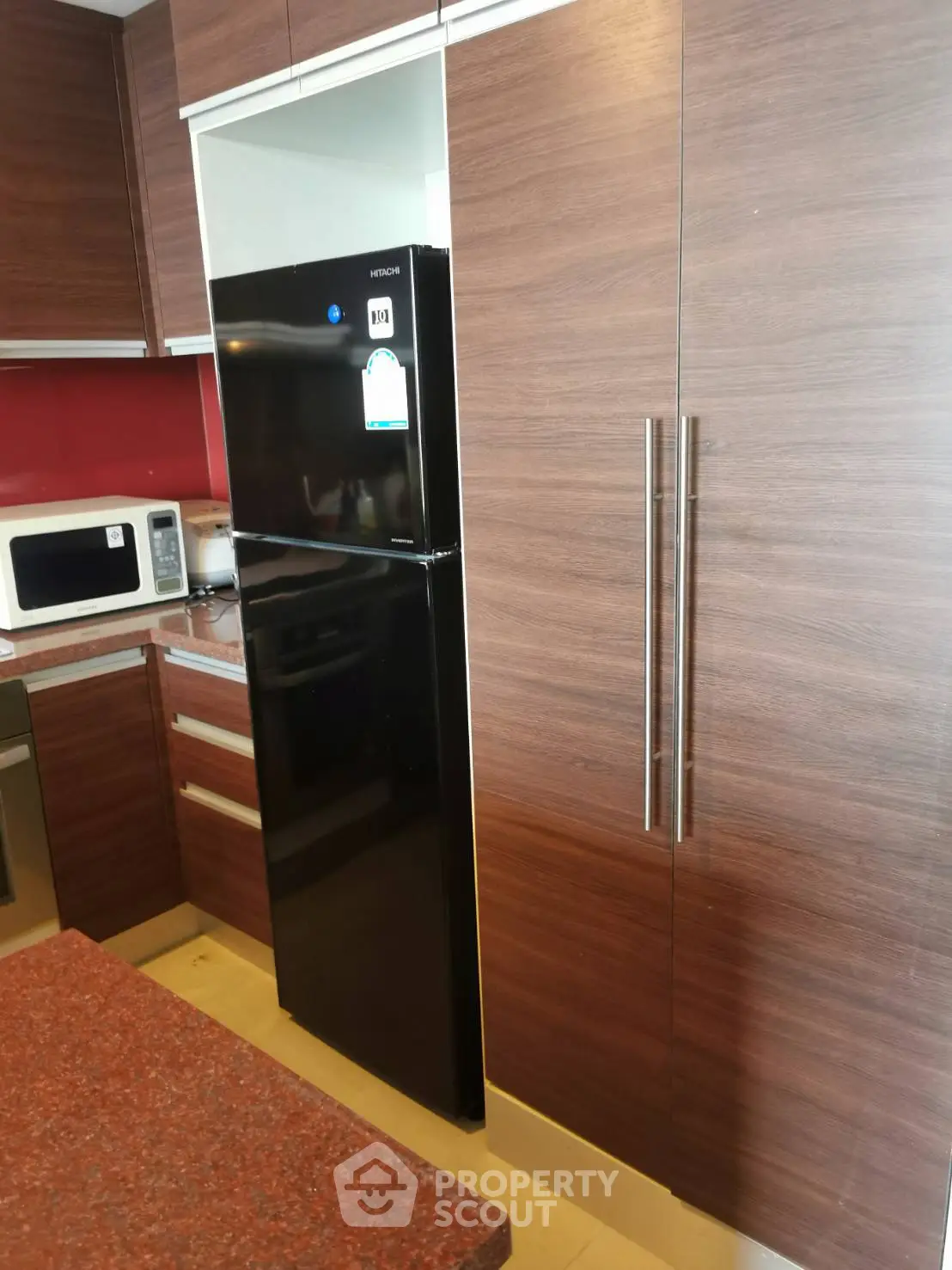 Modern kitchen with sleek wooden cabinets and black refrigerator