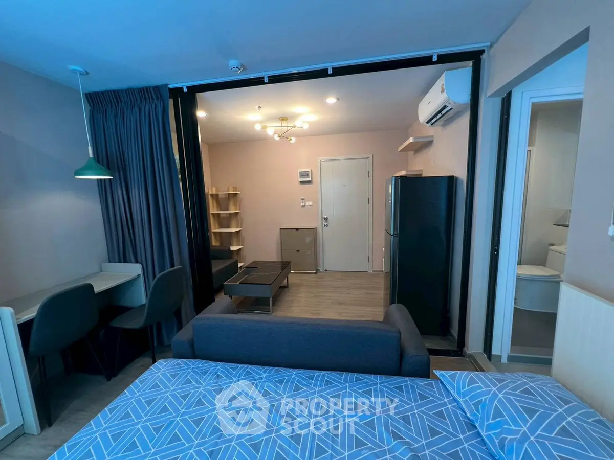 Modern studio apartment with open layout, featuring a cozy living area, stylish furniture, and contemporary lighting.