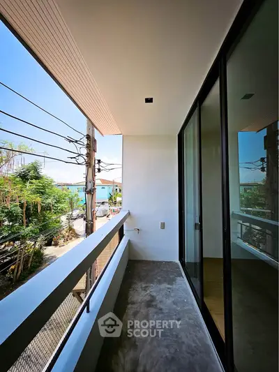Modern balcony with glass doors and street view in a contemporary building.