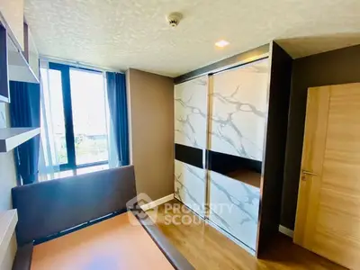 Modern bedroom with large window and stylish wardrobe