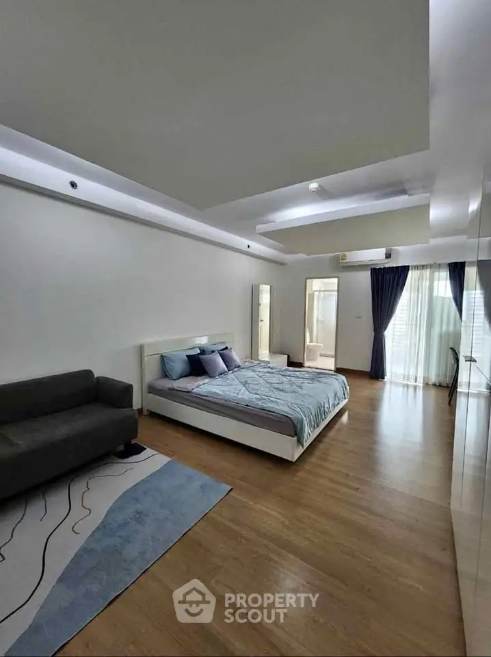 Spacious modern bedroom with elegant decor and natural light