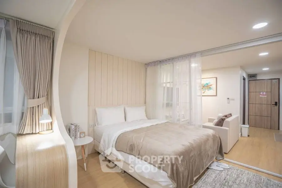 Modern bedroom with cozy decor and sliding glass doors leading to a stylish living area.
