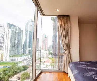 Luxurious bedroom with floor-to-ceiling windows offering stunning city views in a modern high-rise apartment.