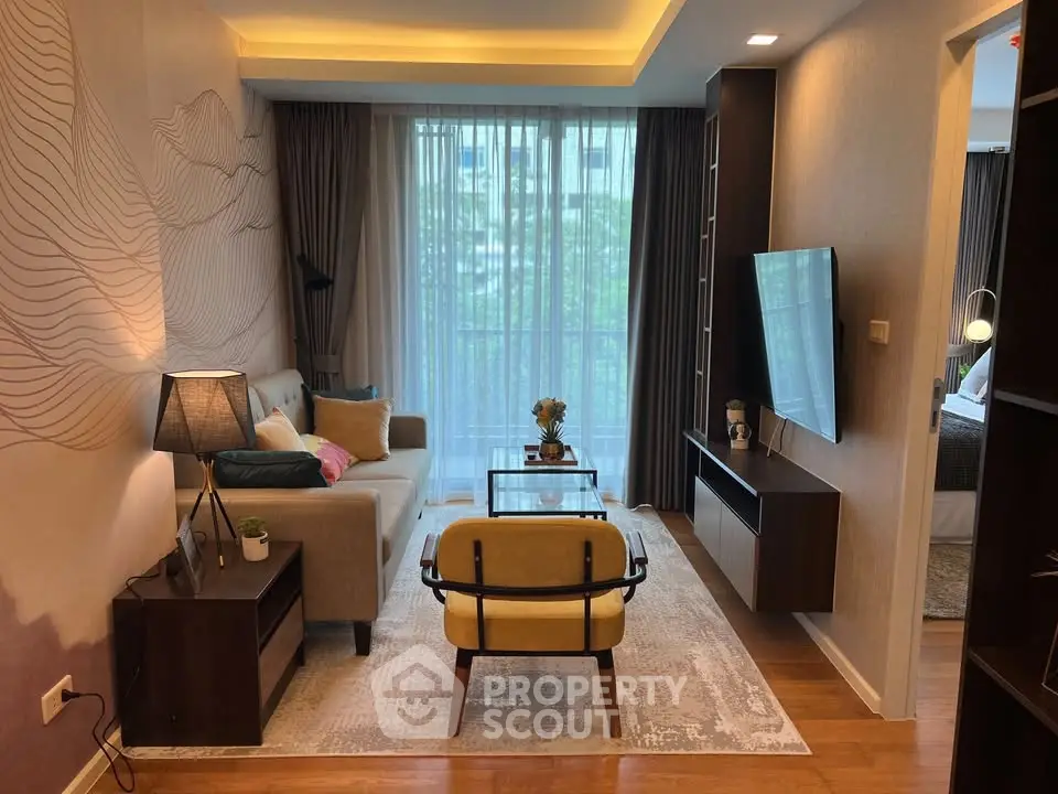 Modern living room with stylish decor and large window view, featuring cozy seating and elegant lighting.