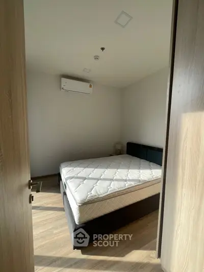 Cozy bedroom with natural light and modern air conditioning unit.