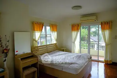Cozy bedroom with balcony access and natural light