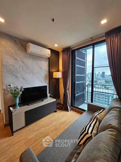 Modern living room with city view, featuring stylish decor and large windows for natural light.