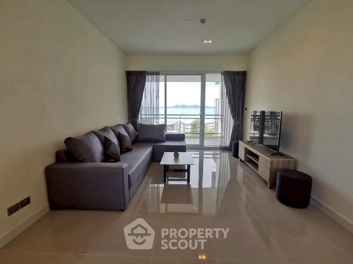 Spacious living room with modern sofa and stunning sea view balcony.