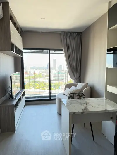Modern living room with city view, featuring sleek furniture and large windows for natural light.
