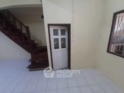 Spacious interior with wooden staircase and unique door design, perfect for creative home decor.